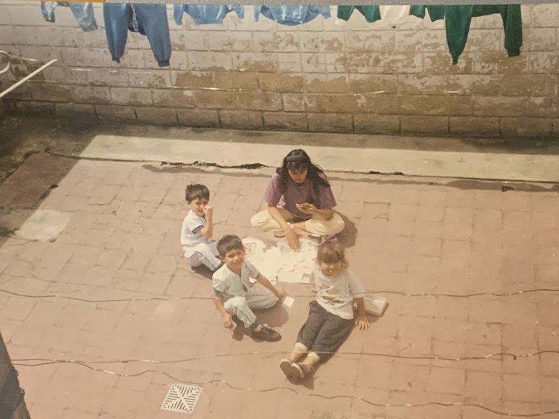 Foto familiar de Stephany de niña en el patio de una casa en Bogotá, con ropa tendida al fondo